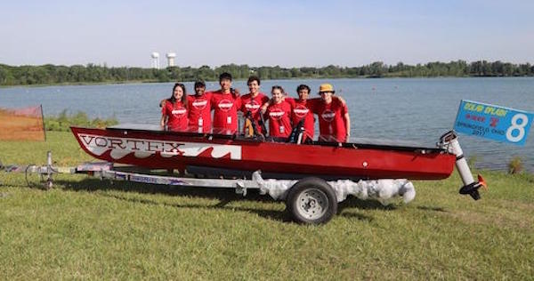 CMU Solar Racing team poses behind red boat "Vortex" at SOLAR SPLASH