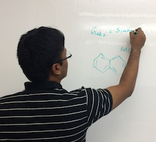 Krishnamurthy writes problems on a whiteboard.