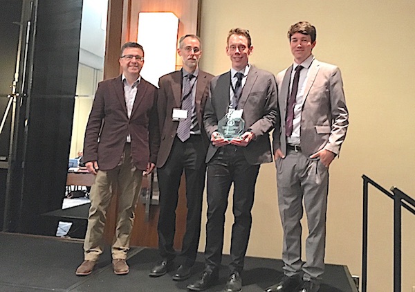 Shawn Litster holds DOE award beside his research collaborators.