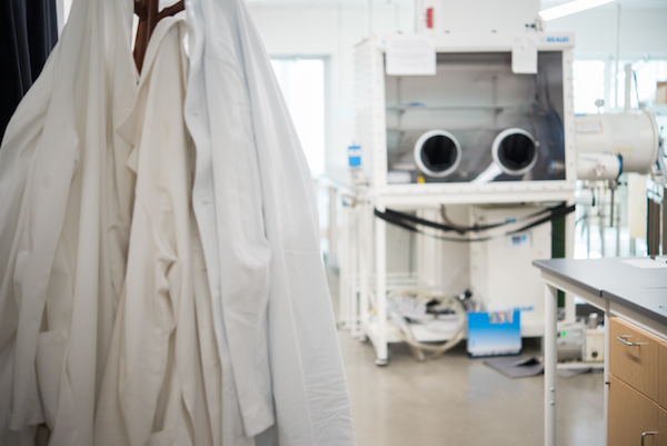 Lab coats hang in an empty laboratory.