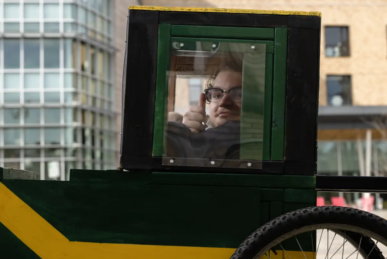 student sitting inside wooden buggy